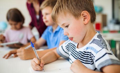 Boy writing with tongue out in concentration