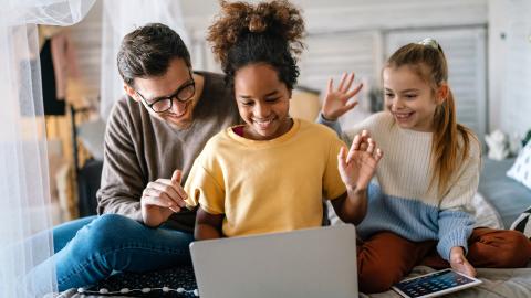 Father with two daughters at computer