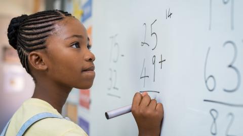Girl doing math at a whiteboard