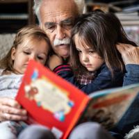 Grandfather reading to two young children