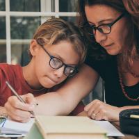 Woman helping child with schoolwork