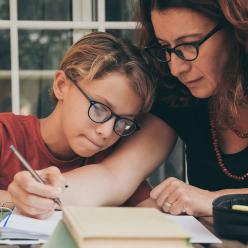 Woman helping child with schoolwork