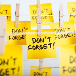 A clothesline holding a bunch of post-its saying Don't Forget