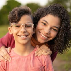 Two siblings smiling at the camera