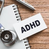 stethoscope, notepad, pen, and ADHD printed on a card