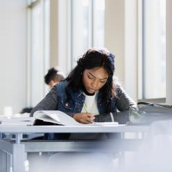 Teen studying at a table.