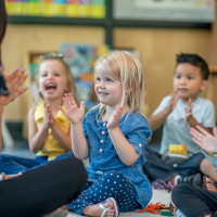 Kindergarteners clapping with their teacher